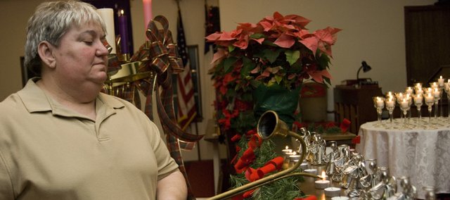 Sue Hollingsworth lights a candle during the 2007 Blue Christmas service at the McLouth United Methodist Church, to honor the memory of her uncle, Harold Roland, a retired Oklahoma highway patrolman, who died last November. This year was the third year the church provided this service for grieving church members during the holidays.