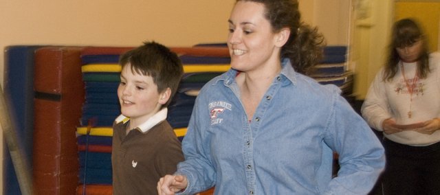 Stacy Willis and Jake Griffin run around the gymnasium at the Tonganoxie Elementary School on Thursday as a part of the Red Shoelace Program: Fighting Childhood Obesity. Ursula Kissinger, TES physical education instructor, brought the pilot program to Tonganoxie after learning about it during a conference.