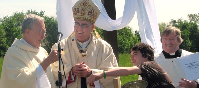 From left, the Rev. Al Rockers, Archbishop Joseph F. Naumann, Alex Smith and Monsignor Gary Applegate laugh along with members of Holy Angels Parish at a ground-breaking ceremony for a new church building. Rockers had just announced he'd drawn his own name in a raffle for a quilt. He quickly decided to select a new winner at Sunday's ceremonies.
