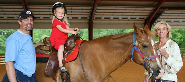 NASCAR driver Kyle Petty (left) and wife, Pattie (right), meet a child at their Victory Junction Gang Camp for chronically ill children in Randleman, N.C. The Pettys plan to open a second camp in Wyandotte County that will allow children to ride horses, swim and canoe despite having serious illnesses.
