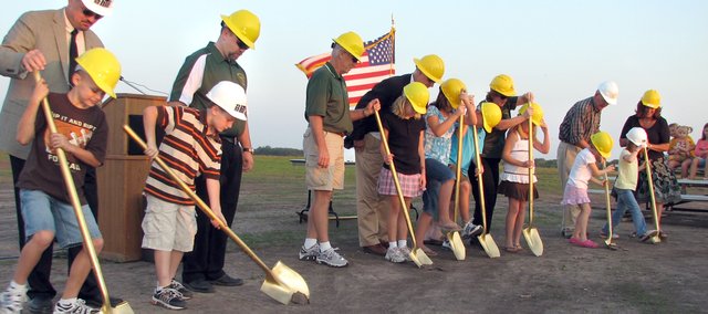 Basehor-Linwood School District elementary students (from left) Dalton Lindelof, Parker Rusk, Rachel Tindell, Katherine Karrick, Brock Gilliam, Payton Rusk, Gabby Coleman and Catie Coleman with the help of school and construction officials turn the first shovels of soil Monday evening at site of the future Basehor Intermediate School. The school, located southeast of the 155th and Hickory streets intersection, is expected to be completed by winter 2009.