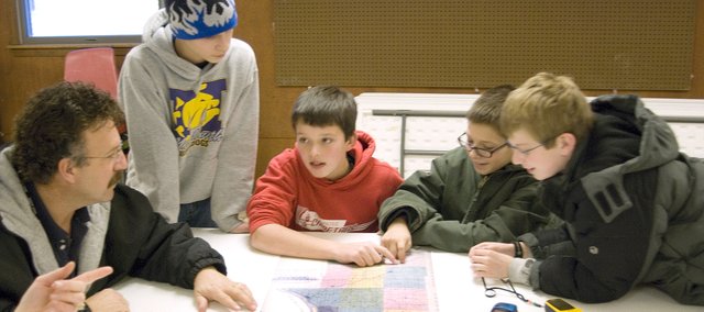 The 4-H GIS Tech Team looks over a map recently discovered by Leavenworth County Geographic Information Systems (GIS) Director Jeff Culbertson, far left. The map is dated 1877 and was printed by the Missouri Publishing Co. The map shows the location of the old schoolhouses in Leavenworth County. The tech team, from left, Cody Koch, 13, Carl Hecht, 12, Levi Koch, 12 and Garrett French, 12, compared the location on the old map with the locations they discovered.
