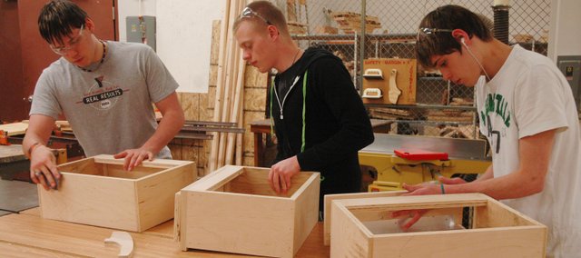 James Storms, left, Devin Dernovish, middle, and William Storms work on drawers that will be installed in the addition of the Bonner Springs High School concession stand. The BSHS woodworking students have been involved in building 60-feet of cabinets for the concession stand, saving the school district $22,000.