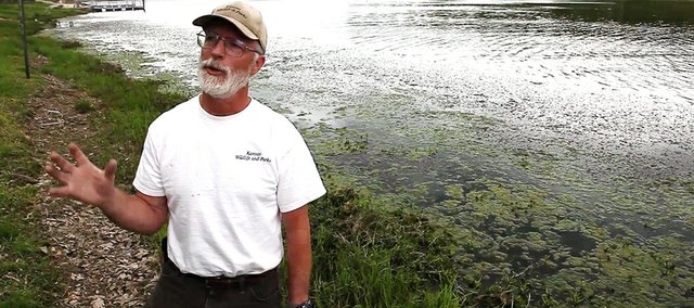 Richard Sanders, district fisheries biologist for the Kansas Department of Wildlife and Parks, talks about the growth of curly leaf pond weed at Lone Star Lake that has some residents, boaters and fishing enthusiasts annoyed. In years past Douglas County officials have allowed a herbicide be sprayed to kill the weed, which Sanders said can provide a nice habitat for fish. The County Commission will decide tonight whether to authorize spraying this year.
