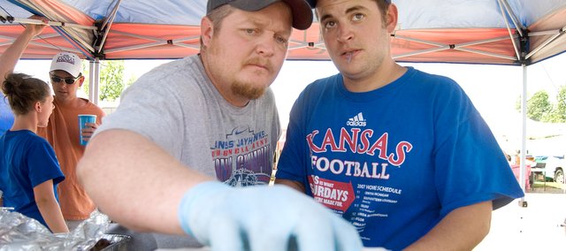 Tim Flory, left, and Chris Chambers of the team Crimson & Blue BBQ Crew, assemble six pieces of their sausage entry into a container that will be delivered to the judges at the McLouth BBQ Blowout. The competition is the Northeast Kansas State BBQ Championship, which is sanctioned by the Kansas City Barbecue Society. The Lawrence team took seventh place overall.