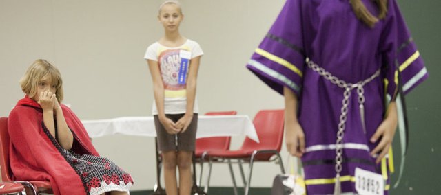 Holly Vesecky, 8, left, a member of the Vinland Valley 4-H Club, waits to compete Monday in the Douglas County 4-H fashion revue. Participants were displaying their sewing projects in the construction category. At center is Hannah Schram, 12, a committee member of the Eudora 4-H Club who was assisting the models, and in the foreground at right is a Choctaw dress modeled by Sabrina Jones, 10, a member of the Clinton Eagles Club. Although there are events throughout the week, the Douglas County Fair really kicks off Friday. Included here is a schedule of events. The Signal will also have a 4-H feature story this week.