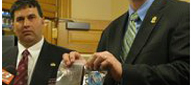 State Rep. Rob Olson (left) and Johnson County forensic scientist Jeremy Morris on Monday display K2 product that they want banned because it contains synthetic substances that they said produces intense high and could be dangerous. Olson, R-Olathe, and Johnson County law officers held a news conference at the Statehouse on the first day of the 2010 legislative session.