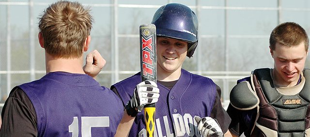 Baldwin High School junior Kyle Pattrick, center, celebrates with juniors Ryan Rogers, left, and Nate Growcock after scoring a run Friday at the Bulldogs’ home opener. BHS lost the game 10-4, but won the second contest against Ottawa 7-6. Baldwin also split its doubleheader at Spring Hill on Tuesday, winning 2-0 and losing 18-5 to the Broncos.