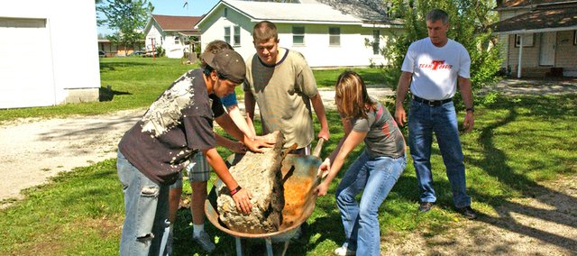 Tonganoxie High School sophomore R.J. Reyes, junior Lisa McClary, freshman Jeffrey Rawls and senior Dezi Steinwachs move a large chunk of concrete Wednesday in the backyard of Pat Conroy's house during the high school's Community Service Day.
Students fanned out across the community to perform different tasks for individuals, the city and organizations during the annual event.