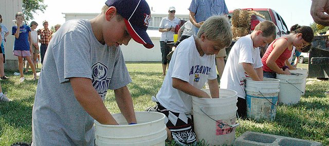 A group of youngsters try their hands at the corn shelling competition during the old-time farm skills at the Vinland Fair Thursday afternoon. The fair continues through Saturday. Friday night's highlight will be a salute to Max Moore, the winner in the first-ever tractor pull in the early 1960s. That will be at 7 p.m. at the arena at the fairgrounds.