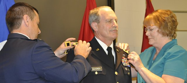 Maj. Gen. John E. Davoren, of Lansing, stands at attention while his wife, Debra, and Maj. Gen. Tod M. Bunting, adjutant general of the Kansas National Guard, pin him with his new rank. Davoren was promoted to major general in a ceremony Aug. 27 at the 35th Infantry Division Headquarters, Fort Leavenworth.