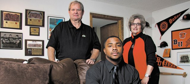 Richie Bryant, center, a fifth-year senior at Baker University, graduated over the weekend. Pictured with Bryant are Dan Harris, the former athletic director at Baker, and his wife, Peggy, the dean of education at Baker. The Harrises took Bryant into their home, giving him a place to live as he finished his degree.
