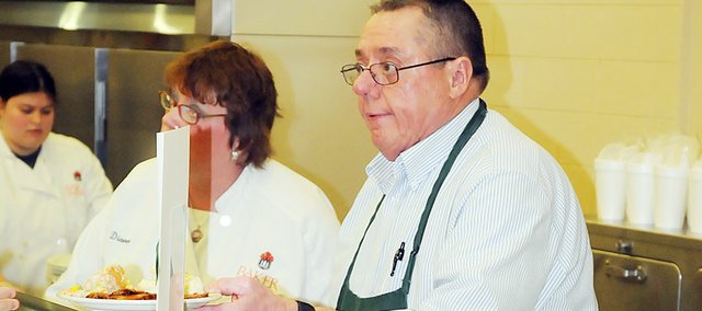 Darrell Bowersox serves a lunch Tuesday at Baker University’s Harter Union cafeteria. The Baker University directory of food services will retire June 30 after 26 years on the job, during which he introduced higher standards in food service. The university will honor Bowersox with a reception from 2 to 4:30 p.m. Wednesday at Collins House.
