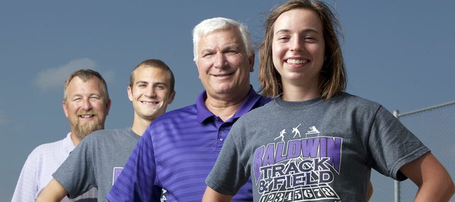 Baldwin High School sophomore Kaitlyn Barnes, right, is pictured with girls track coach Ted Zuzzio, junior Brian Wright and boys track coach Mike Spielman on Monday at Baldwin High. The Bulldogs won state titles this past year in boys and girls track & field, along with boys and girls cross country. They became the first school in Kansas history to sweep both state titles in the same school year.