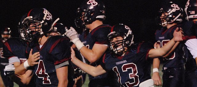 St. James Academy's Tanner Hinderliter (4) and Scott Luby (13) lead the celebration late in the Thunder's 33-19 victory against defending Class 4A state champion Louisburg.