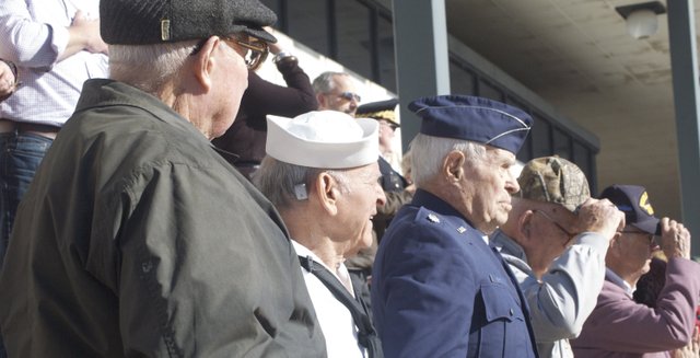 World War II veterans, at the reviewing stand at the Leavenworth County Veterans Day Parade, stand after saluting a color guard in the parade in downtown Leavenworth on Friday, Nov. 11. Pictured are, from left, retired Army Lt. Col. Harry Davis of Leavenworth; retired Army Col. B.B. Albert Jr. of Parkville, Mo. (who served in the Navy during WWII); and retired Air Force Lt. Col. Bill Adams of rural Leavenworth. Many parade participants stopped in front of the stand to thank the veterans there for their service.