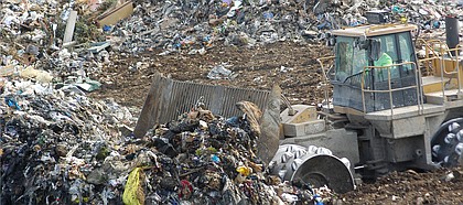 As trucks dump load after load of garbage and debris into the active cell at the landfill, a corps of heavy machine operators work continuously to level and bury the trash.