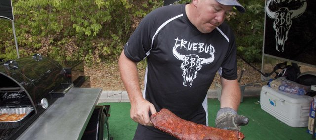 Truebud BBQ team member Boyd Abts of Eudora pulls a slab of ribs off the smoker during the Smokin' on Oak barbecue competition, Aug. 25, 2012, in Bonner Springs. Truebud is one of the top barbecue teams in the country right now, spending most of this barbecue season in the top 10 of the Kansas City Barbeque Society's Team of the Year points chase.