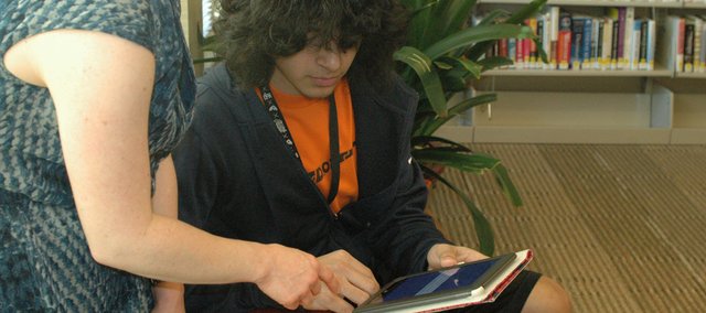 Erica Voell, youth and teen librarian, shows Andrew Flores, Bonner Springs High School senior, how to access an e-book on her Nook using the new OverDrive system the Bonner Springs City Library plans to launch Dec. 1. The Bonner library also hopes to soon have e-reader devices like the Nook and others (shown at right) available for patrons to check out, Kim Beets, library director, said.