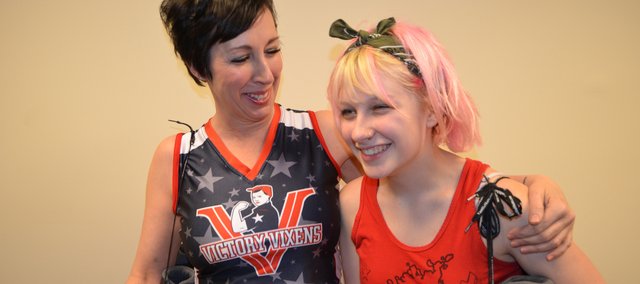 Mary Strafuss, left, a new member of the Kansas City Roller Warriors’ Victory Vixens team, shares a laugh with her daughter Meara Roach, who participates in a junior roller derby program. Meara encouraged her mom to participate in the sport, which has helped the family rebound from a broken marriage.