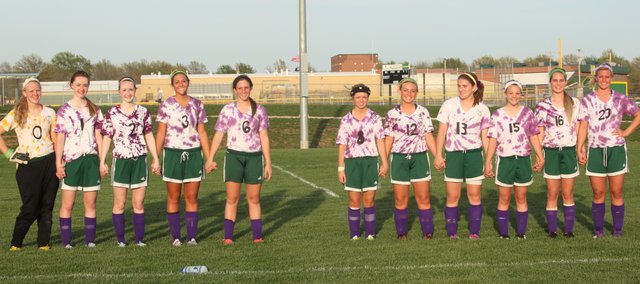 The Basehor-Linwood girls soccer team donned purple tie-dyed jerseys for Monday's game against Mill Valley. The Bobcats wore the jerseys to remember freshman Shealynn Hayes, who passed away last week. After the game, the starting lineup gathered, saving a spot for Hayes. Pictured, from left to right: Sophomore Brianne Kennedy, freshman Courtney Robinson, junior Hailey Robinson, freshman Nicole Rutherford, sophomore Megan Sixta, senior Jordan Nirschl, junior Ally Laney, sophomore Raeney Seaton, sophomore Julie Lough and senior Kara Stephens.