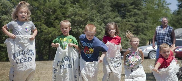 Leaping to the finish line, children compete in a gunny sack race at a recent Vinland Fair on the fairgrounds north of Vinland. The three-day fair returns Aug. 8 with its focus of old-fashioned family entertainment, featuring such things as live music, games, animal shows, a lawn mower driving competition and a homemade ice cream contest.