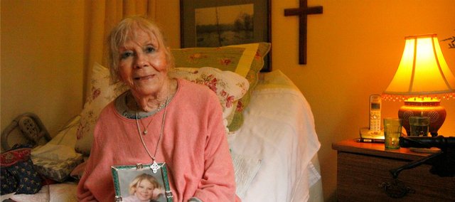 Milly Lally, a longtime Shawnee resident, sits with a photo of her granddaughter in her room at New Mark Assisted Care in Kansas City, Mo. Lally recently had a tattoo sketched on her left leg, a tribute to her granddaughter.