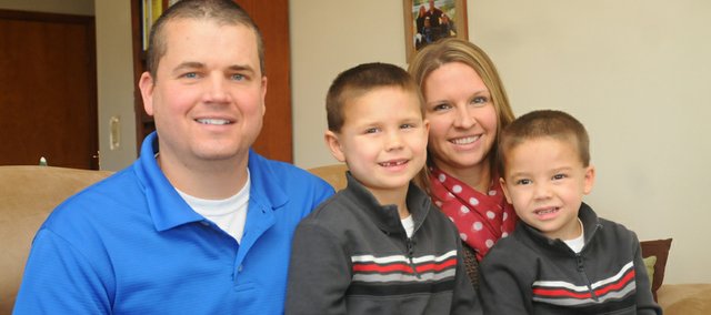Justin Hoffman, left, will graduate Saturday from Kansas University with a 3.90 grade-point average and as a member of the National Honor Society more than a decade after he was dismissed from the school because of poor grades. The 34-year-old rural Baldwin City man credits his academic turnaround to the support of his wife, Julie, third from left, and the motivation provided by his two sons, 6-year-old Caden and 4-year-old Mason, right.