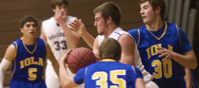 Michael Burton, in white, fights for control of the ball against two Iola players. The Baldwin senior forward had a game-high 17 points in the Bulldogs' 58-33 victory Wednesday against the Mustangs. With the win, Baldwin will play Louisburg a 7:30 p.m. Friday at the BJHS gym for the Bulldog-Wildcat Class title.