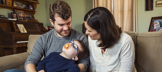 Ryan and Kathy Reed share a moment with their 2-year-old son Otis, who experiences hundreds of seizures daily and is now in a lower-body cast for a broken femur caused by medications, a diet meant to help reduce the seizures and lack of physical activity. With the failure of medication to improve Otis' condition, Ryan will relocate May 1 to Colorado so his son can start medical marijuana treatments.