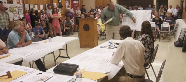 Kent Vedder of BFA Engineering comment on a feature of the Wal-Mart Express development plan at Tuesday's Baldwin City Planning Commission meeting while some of the about 100 residents in attendance look on. Planning commissioners tabled the development plan pending the submission of a traffic study and the Baldwin City Council's review of the development plan's compatibility with the city 2008 comprehensive plan.