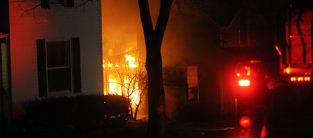 Flames leap Monday evening through windows at a house at 1017 Grove Street. John Baker said the house he rented to Tom and Sarah Johnson and their three children appears be a total loss. 