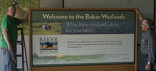 Jon Boyd, manager of the Baker Wetlands, and his father Roger Boyd, Baker director of natural areas, show off one of the display cases with graphic panels that would be on display at the Baker University Wetlands Discover Center. There will be an open house for the new Discovery Center from 9 a.m. to 4 p.m. Saturday and 1 to 4 p.m. Sunday.