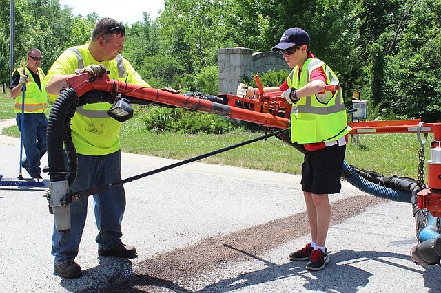 Mayor for a Day Paul Hartman helped city employees patch cracks and potholes on a residential road last Thursday afternoon.