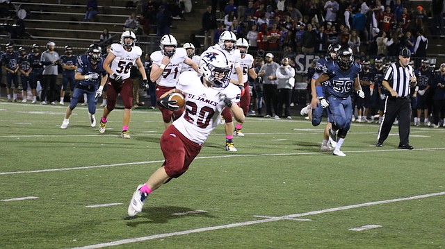 St. James Academy football senior Hudson Manning (No. 20) runs upfield for a touchdown against Blue Valley North High School Friday at the Blue Valley District Activity Complex in Overland Park.