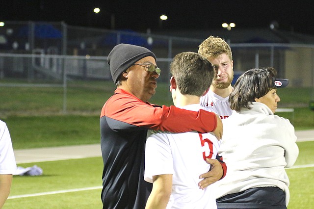 Shawnee Mission North High School soccer head coach Jaime Velez (left) hugs senior Jack Spencer (No. 5, right) following a playoff loss to Olathe Northwest High School Tuesday night at the College Boulevard Activity Center in Olathe.