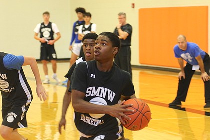 Shawnee Mission Northwest boys' basketball freshman Damar'e Smith (center) drives for a layup attempt in a scrimmage Saturday morning at Shawnee Mission Northwest High School in Shawnee.