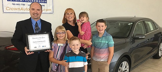 Tonganoxie High School music director Charles Van Middlesworth celebrates his teaching award at Crown Automotive in Lawrence. Crown, Minsky's Pizza and Midco Sports Network recently announced that Van Middlesworth won their 2018-19 Educator of the Year award. Pictured with Van Middlesworth is his wife, Kristan, and children Aiden, 13, Piatyn, 10, Declan, 7, and Daigen, 4. As part of his award, Van Middlesworth received $1,000 for himself and another $1,000 for THS. He also gets to drive a 2018 Volkswagen Passat for a year.