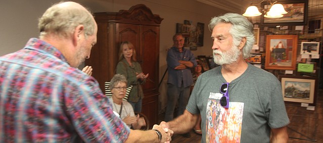 Artist Ken Bini receives an award from judge John Hulsey during the Plein Art Festival on Aug. 31 at the Village Event Venue in downtown Tonganoxie.