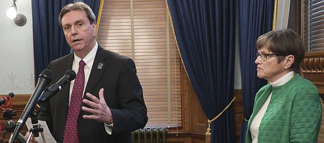 Kansas Education Commissioner Randy Watson, left, discusses an order from Gov. Laura Kelly, right, to close the state's public and private K-12 schools for the rest of the semester, Tuesday, March 17, 2020, at the Statehouse in Topeka, Kan. Watson says a task force will have recommendations for continuing teaching online and in small groups. (AP Photo/John Hanna)