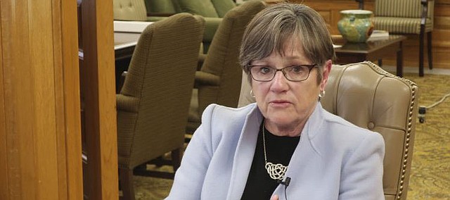 Kansas Gov. Laura Kelly answers questions about attempting to check the spread of the new coronavirus during an interview with The Associated Press in her office, Wednesday, March 25, 2020, at the Statehouse in Topeka, Kan. Kelly says the federal government should force industries to manufacture medical supplies to address a shortage of ventilators, protective masks and testing kits. (AP Photo/John Hanna)