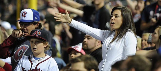 In this May 2, 2014, file photo, Atlanta Braves fans do the tomahawk chop during the ninth inning of a baseball game with the San Francisco Giants, in Atlanta. The Atlanta Braves say they have no plans to follow the lead of the NFL's Washington Redskins and change their team name. The team said in a letter to season ticket holders they are examining the fan experience, including the tomahawk chop chant, and have formed a "cultural working relationship" with the Eastern Band of the Cherokees in North Carolina. (AP Photo/David Tulis, File)
