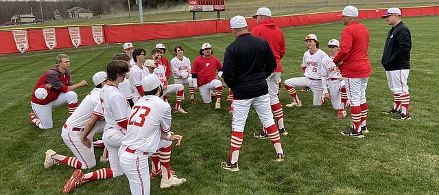 Tonganoxie High baseball coach Mitch Loomis chats with his team as THS assistant coaches look on Monday evening after THS’ season opener against Lansing at the Leavenworth County Fairgrounds. Lansing erased a first-inning 1-0 deficit and went on to win, 3-1, in the non-conference game.