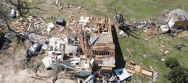 A home is destroyed from a possible tornado the night before near Andover on Saturday. A suspected tornado that barreled through parts of Kansas has damaged multiple buildings, injured several people and left more than 6,500 people without power.