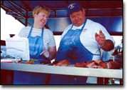 Faithful participants of the Tonganoxie Days barbecue cookoff,
Mindy and Rick Danberry, Basehor, prepare their pork roast for the
judges. The Danberrys have participated in every Tonganoxie Days
barbecue competition.