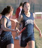 Regan Sisson passes the baton to Tori Tunget in the 3,200-meter
relay at Thursday's Bobcat Relays in Basehor. The Eudora girls
finished the race in a little more than 11 minutes. Both the boys
and girls track teams placed first at the meet.