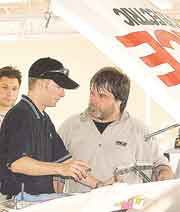 Team Chick driver Eric Jones, center, talks to truck chief and
chassis set-up man Bud Haefele about the truck's performance while
mechanic Louis Paternico looks on.