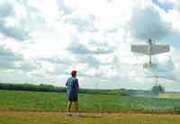 John Wells walks behind his hovering radio-controlled model
airplane Friday at the 95th Street Flying Group's new home in De
Soto's east bottoms. Forty-three club members, the group's limit,
fly there at various times during the week.