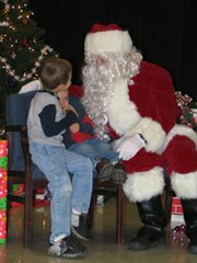 Alex White, 5, and his brother Mykael, 2, tell Santa what they want for Christmas at the Lansing Parents and Teachers Association's Breakfast with Santa on Saturday.
