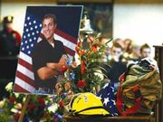 The hat and uniform of volunteer firefighter Jared Moore stood in
the center of the memorial service Monday at Savior of the World in
Kansas City, Kans.